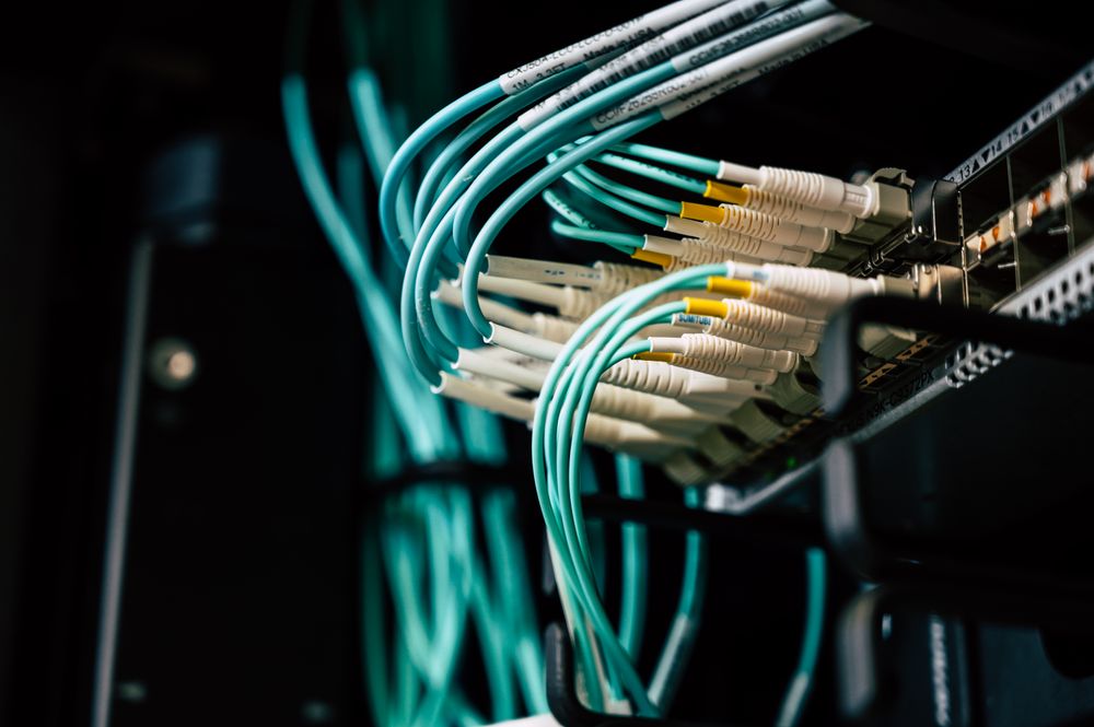 Glowing fiber optic cables connected to a network switch